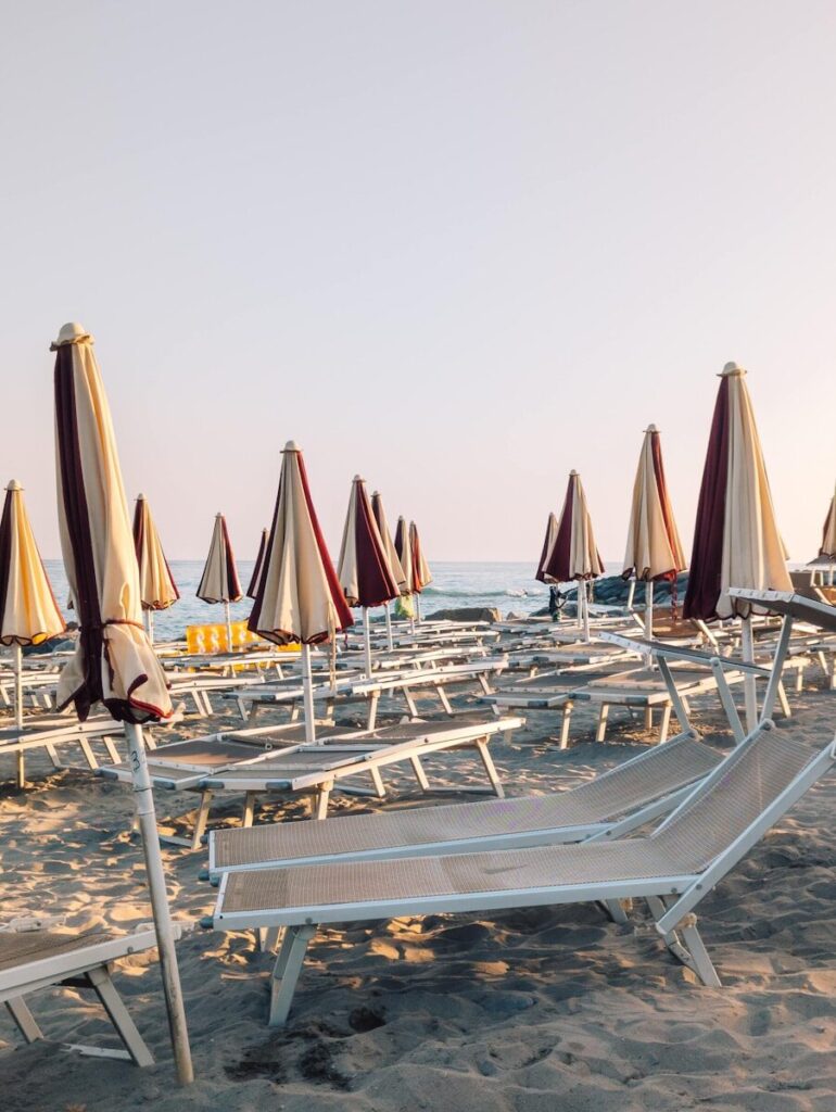 Beach chairs and umbrellas on a sandy shore.